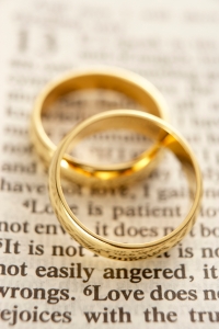 Two Wedding Rings Resting On A Bible Page